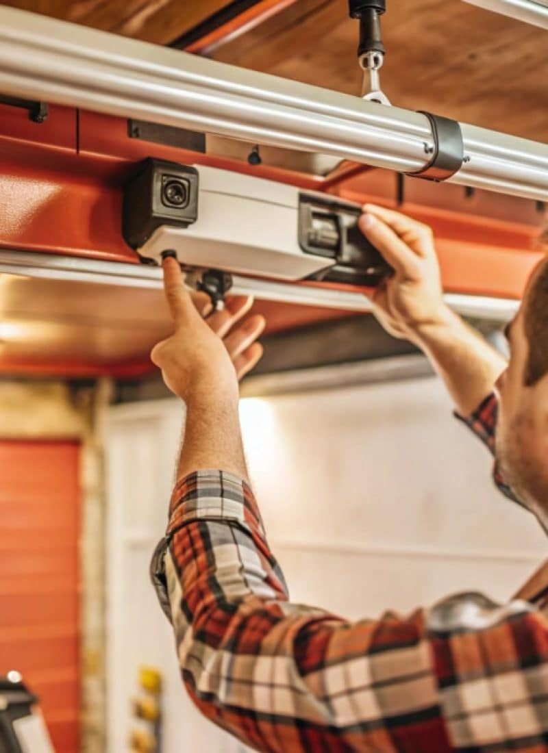 Detalle del sistema de motor y automatismo durante la instalación de una puerta automática en un entorno residencial.
