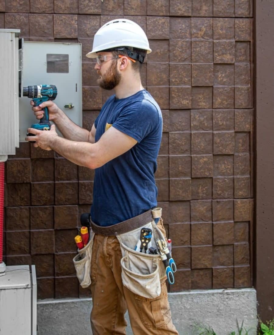 Técnico especializado realizando la reparación de una puerta automática en un garaje comunitario.